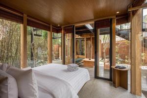 a bedroom with a white bed and glass walls at Blackbird Hotel Bandung in Padasul +256 photos