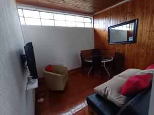 a room with a bed and a table and a television at Javiera Centro Osorno in Osorno
