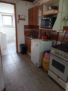 a small kitchen with a stove and a microwave at Javiera Centro Osorno in Osorno +10 photos