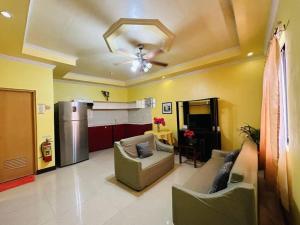 a living room with a couch and a refrigerator at Coco Mango's Place in Panglao