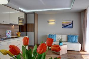 a kitchen and a living room with red tulips at Marina Jastarnia Apartamenty w budynku z Basenem in Jastarnia