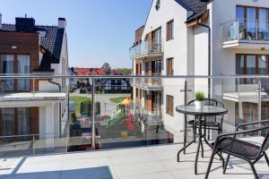 Apartament dysponuje balkonem ze stołem i krzesłami. w obiekcie Marina Jastarnia Apartamenty w budynku z Basenem w Jastarni