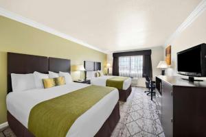 a hotel room with two beds and a flat screen tv at Best Western Executive Inn in Los Banos +75 photos