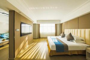 a bedroom with a large bed and a television at Downtown Hotel in Zhuhai +37 photos