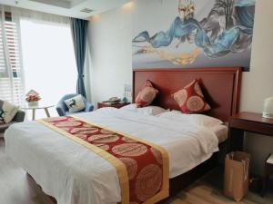 a bedroom with a large bed and a painting on the wall at GreenTree Inn Suzhou Shengze Hotel in Suzhou +247 photos
