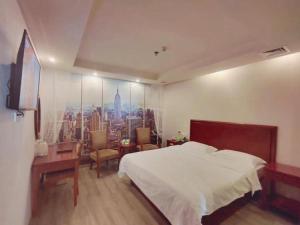 a bedroom with a bed and a desk and a window at GreenTree Inn Suzhou Shengze Hotel in Suzhou