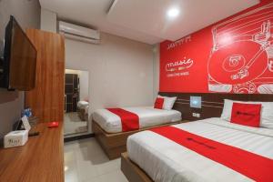 a hotel room with two beds and a largevertisement at Hotel JAV Front One in Lahat +165 photos