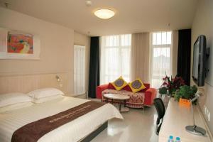 a hotel room with a bed and a couch at Jinjiang Inn Baotou Saihan Tara Park Youyi Street in Baotou +212 photos