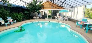 a swimming pool with chairs and a table and an umbrella at Château de Montmireil in Canisy