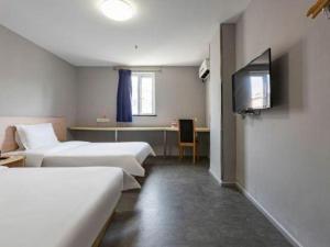 a hotel room with two beds and a flat screen tv at 7 Days Inn Nanchang Bayi Square Zhongshan Road Wanshou Palace in Nanchang