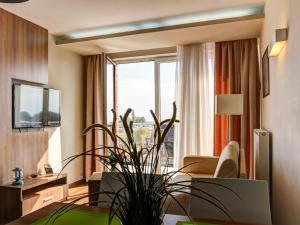 ein Wohnzimmer mit einem Sofa und einem großen Fenster in der Unterkunft Marina Jastarnia Apartamenty w budynku z Basenem in Jastarnia