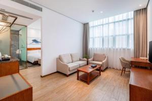salon z 2 krzesłami i pokój z łóżkiem w obiekcie H Life Hotel (Shenzhen Sea World Branch) w mieście Shenzhen