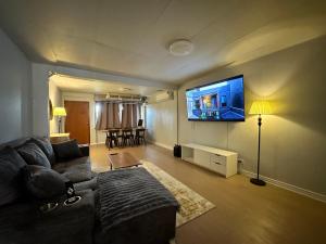 Una sala de estar con un sofá y un televisor de pantalla plana. en Mango Hostel - 420 Friendly, en Bangkok