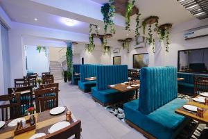 a restaurant with blue booths and tables and chairs at LP Regency in Pune