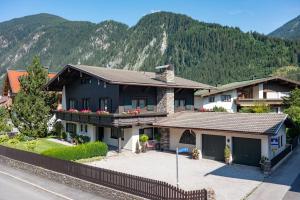 una casa con una valla delante de una montaña en Jagdhaus, en Mayrhofen