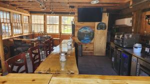 a dining room with a long wooden table in a cabin at Allen Gulch Motel in Hill City