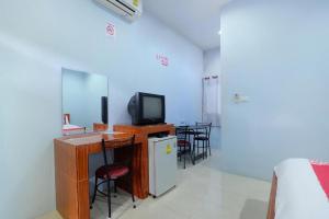 a room with a tv and a table with chairs at OYO 675 Phu Ching Resort in Ao Nang Beach