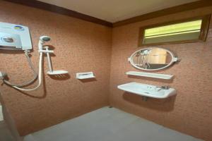 une salle de bain avec un lavabo et un miroir dans l'établissement OYO 75380 Bannoichynum Resort Kanchanaburi, à Ban Tha Kilen (1) 68 autres photos