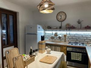 a kitchen with a table and a clock on the wall at Agroturism Sesuri 151 in Şesuri +47 photos