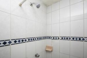 a bathroom with a shower with blue and white tiles at OYO La Casita in Quinceo +96 photos