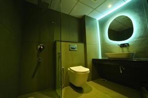 a bathroom with a shower and a toilet and a sink at Yuvraj Land Mark in Mysore