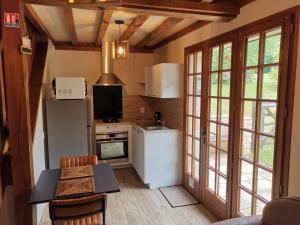 a kitchen with a refrigerator and a table with chairs at Domaine le Manège - Gite Le Phare - près d'Etretat in Sainte-Marie-au-Bosc