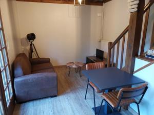 ein Wohnzimmer mit Sofa und Tisch in der Unterkunft Domaine le Manège - Gite Le Phare - près d'Etretat in Sainte-Marie-au-Bosc + 6 Fotos