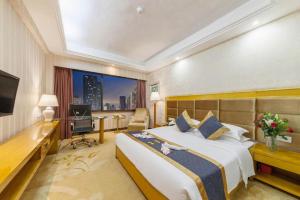 a hotel room with a large bed and a desk at Xiamen Plaza Hotel in Xiamen +263 photos
