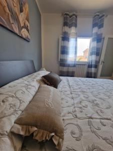 Un dormitorio con una cama con dos almohadas y una ventana. en La casa di Claudia - Certaldo, en Certaldo