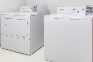two whitewashes and a washing machine in a room at Super 8 by Wyndham Logansport in Logansport