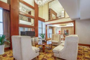 a living room with chairs and a table and a tv at Changsha Xiaoxiang Huatian Hotel in Changsha