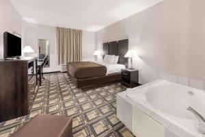a hotel room with a bed and a bath tub at Suburban Studios Mason Hwy 42 in Mason
