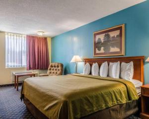 a hotel room with a large bed and a chair at SureStay Hotel in Salina +99 photos