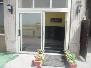 a glass door with two potted plants in front of it at Royal Crown Hotel عائلات فقط in Alexandria
