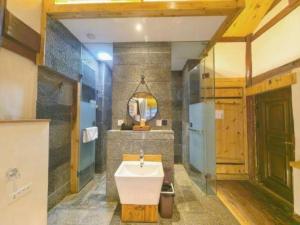 Shangrila Agedtree Hotel في شانغريلا: حمام مع حوض ومرآة +290 صورة