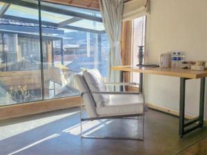 Shangrila Agedtree Hotel في شانغريلا: كرسي أبيض جالس في غرفة مع طاولة