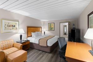 une chambre d'hôtel avec un lit et un bureau dans l'établissement Baymont by Wyndham Knoxville I-75, à Knoxville