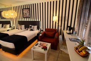 a hotel room with a bed and a chair and a table at Tempo Fair Suites in Istanbul