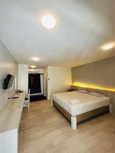 a bedroom with a bed and a desk and a television at Kiatnakhon Hotel in Nakhon Si Thammarat