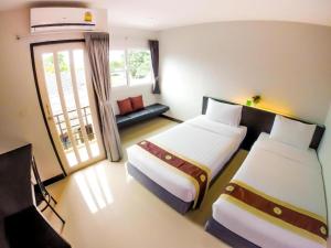 a hotel room with two beds and a couch at My Place Phuket Airport Mansion in Patong Beach +38 photos