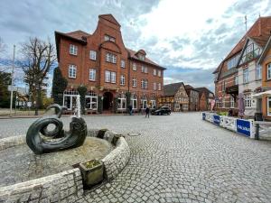 a cobblestone street with a statue in the middle of a city at TooHuus in Hitzacker