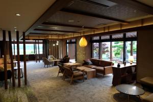 a living room with couches and tables and windows at Kangetsuen in Otofuke