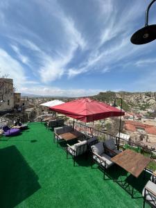 a group of tables and chairs on a roof with green grass at Bella vista stone house in Urgup