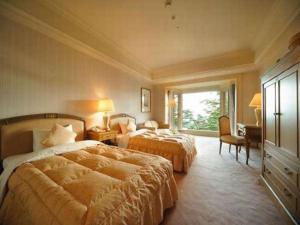 een hotelkamer met twee bedden en een raam bij Hotel de Premiere Minowa in Numajiri