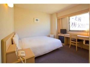 a hotel room with a bed and a desk at Hotel South Garden Hamamatsu in Hamamatsu