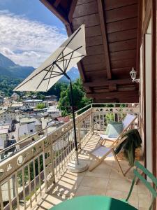 a patio with a chair and an umbrella on a balcony at Loft über Berchtesgaden in Berchtesgaden