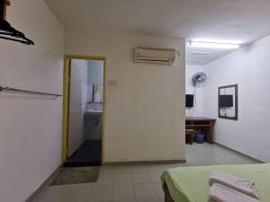 a room with a hallway with a door and a room with a bed at Rumah Tumpangan Abby in Ipoh