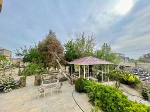 a gazebo with a bench and a table at Serenity Garden Home in Sumqayıt