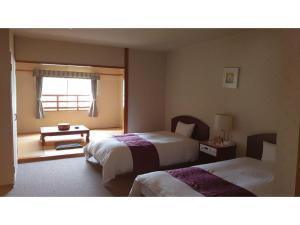 a hotel room with two beds and a window at AKISAWA HOTEL in Sukumo +134 photos