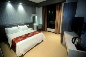 a hotel room with a bed and a television at Star-Well hotel in Kuala Lipis